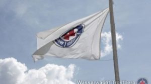 Wasserwachtsfahne an der Rettungswache im Freibad Trostberg.